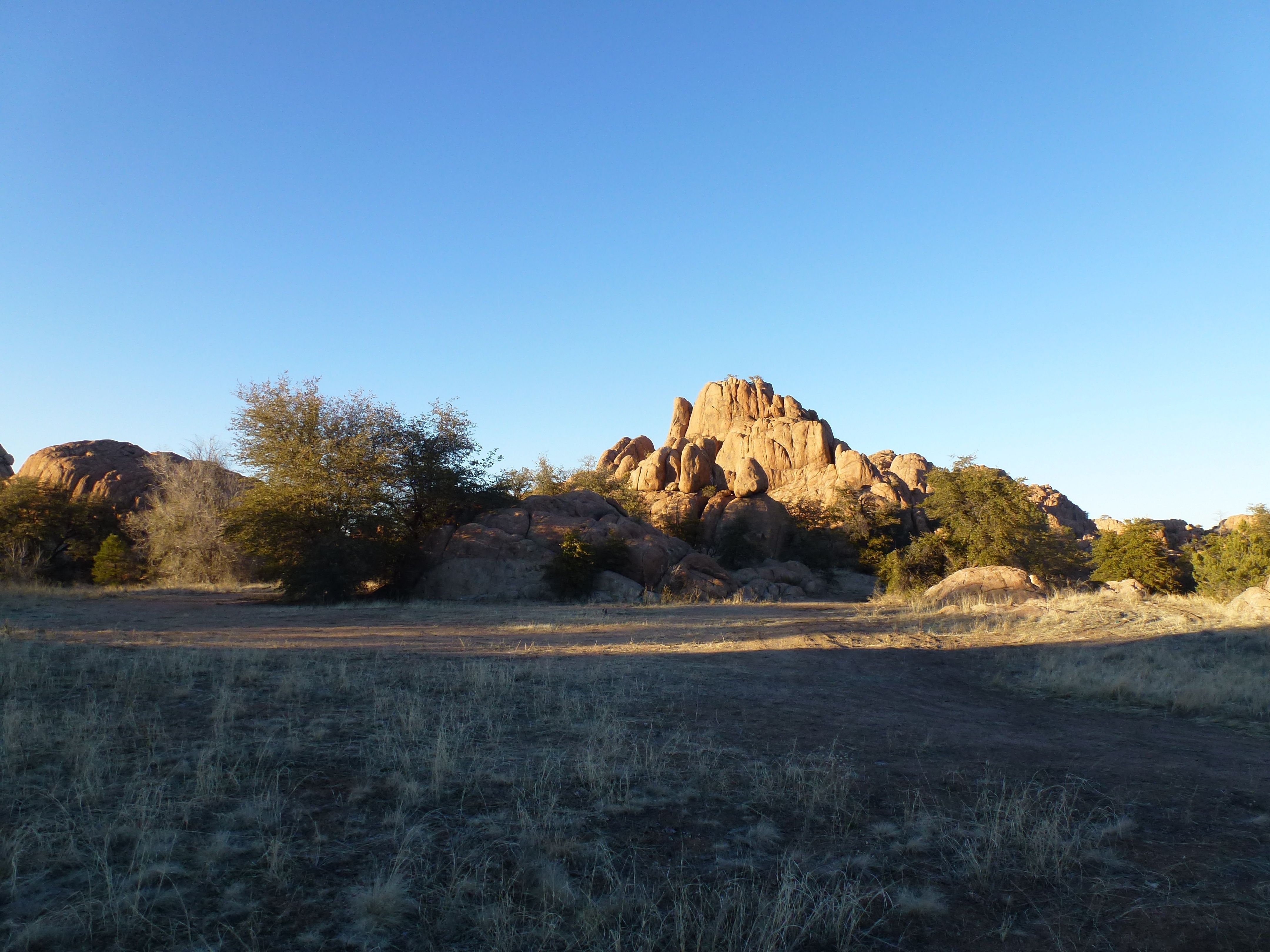 Granite Dells boulder formation rising over a meadow in Prescott, Arizona